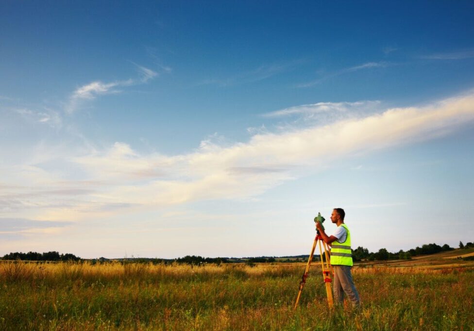 man surveying land for custom home build